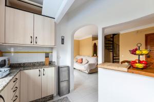 a kitchen with white cabinets and a living room at Yourhouse El Xiprer in Pollença
