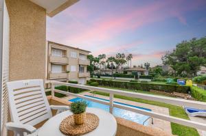a balcony with a table and a chair and a pool at Yourhouse El Xiprer in Pollença