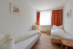 a room with two beds and a table and a window at Skyline House Ferienapartments in St. Moritz
