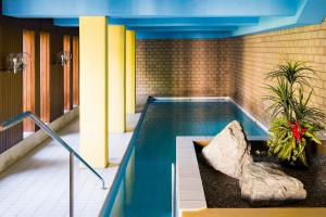 a swimming pool in a building with a rock at Skyline House Ferienapartments in St. Moritz