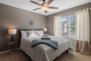 Un dormitorio con una cama con ventilador de techo. en New Bama Retreat Sleeps 8, en Tuscaloosa