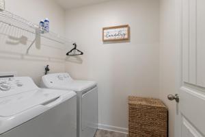 Un baño blanco con lavabo y lavadora. en New Bama Retreat Sleeps 8, en Tuscaloosa 31 fotos más