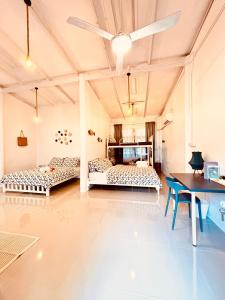 a large room with two beds and a table at P Vacation Libong in Ko Libong