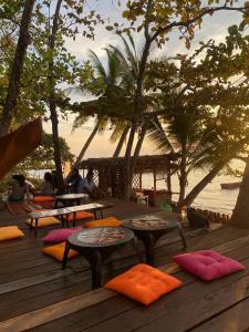 a deck with tables and pillows on the beach at P Vacation Libong in Ko Libong