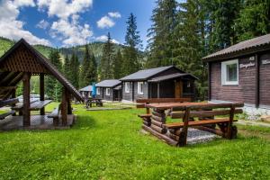 a group of lodges in a field with green grass at Chaty Jasná in Demanovska Dolina