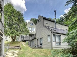 a large white house with a chimney on a hill at Charming Condo in the Mont Tremblant Ski Village in Mont-Tremblant