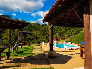 un resort con piscina e montagna di Pousada Natureza da Terra a Monte Verde