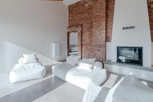 a living room with two white chairs and a fireplace at Santa Caterina Country House - cozy villa with garden in Rocca D'Arazzo