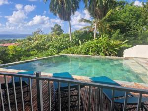 a swimming pool on the balcony of a resort at villa Aymanne in Grand-Bourg