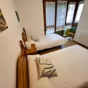 two beds in a room with two beds sidx sidx sidx sidx at Pico Erata, wifi y renovado - Arafita Apartamentos in Biescas
