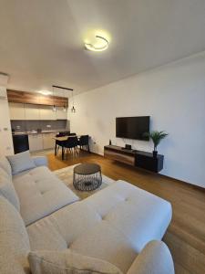 a living room with two white couches and a table at Skyline Cozy Suites in Novi Sad