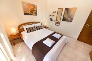 a bedroom with a large bed with two towels on it at Apartment Dream Holidays - 500 meters to beach in Ialyssos