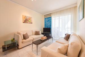 a living room with a couch and a tv at Apartment Dream Holidays - 500 meters to beach in Ialyssos