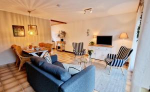 a living room with two blue couches and a television at LittleHome in Gerolstein