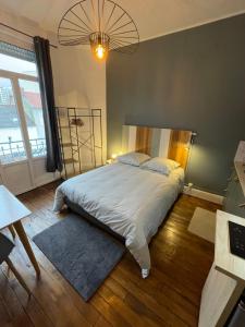 une chambre avec un grand lit et une grande fenêtre dans l'établissement Opale 1, à Vichy