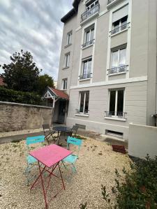 une table et des chaises devant un bâtiment dans l'établissement Opale 1, à Vichy