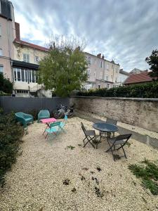 - un groupe de tables et de chaises dans une cour dans l'établissement Opale 1, à Vichy 4 autres photos