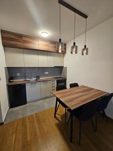 a kitchen with a wooden table in a room at Skyline Cozy Suites in Novi Sad