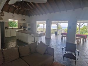 a living room with a couch and a kitchen at villa Aymanne in Grand-Bourg