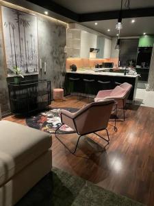 un salon avec un canapé et des chaises et une cuisine dans l'établissement Sky Loft - Modern Oasis in the heart of the city, au Cap