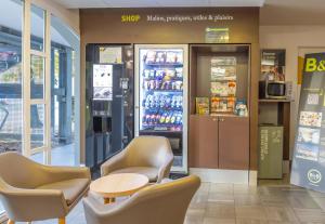 ein Laden mit Stühlen und einem Tisch und einem Kühlschrank in der Unterkunft B&B HOTEL Saint-Malo Centre in Saint-Malo