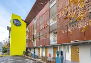 ein Gebäude mit gelber Wand und Parkuhr in der Unterkunft B&B HOTEL Saint-Malo Centre in Saint-Malo