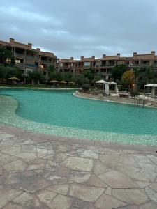 einem Pool mit grünem Wasser und Gebäuden im Hintergrund in der Unterkunft Harmonie d Agdal Marrakech avec Piscine in Marrakesch