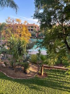 ein Park mit Bäumen und einem Wasserkörper in der Unterkunft Harmonie d Agdal Marrakech avec Piscine in Marrakesch