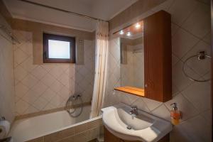 W łazience znajduje się umywalka i wanna. w obiekcie Guesthouse Moucha w mieście Moúcha +33 zdjęcia