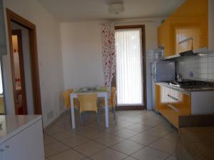 Una cocina con una mesa y sillas en una cocina. en Villaggio Tulipano, en Bibione