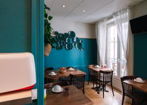 a restaurant with wooden tables and a blue wall at Hôtel du Dauphin in Lyon