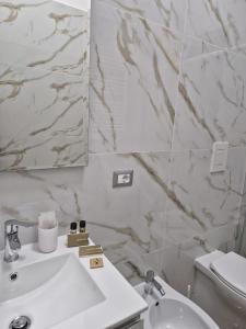 a white bathroom with a sink and a mirror at Nocera a Due Passi in Nocera Inferiore
