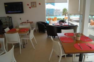 a restaurant with tables and chairs with red place settings at Laguna Bahia Fernanda in Algarrobo