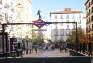a metro sign on a street in a city at Apartamentos Gravina in Madrid