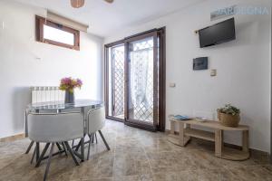 アルゲーロにあるLarge Villa Mediterranea in the heart of Coral Shore with swimming pool large garden with palm treesのテーブルとテレビのあるリビングルーム