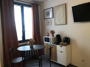 a small room with a table and a microwave at Studio Doré in Alençon