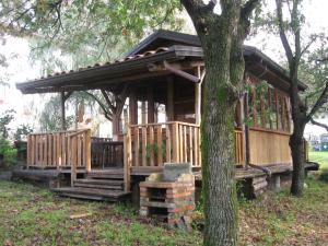 a large wooden cabin with stairs and a tree at Agriturismo Il Casotto in Maida