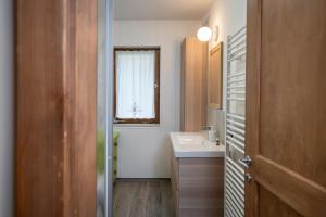 łazienka z umywalką, lustrem i oknem w obiekcie Casa del Salice w mieście Carano +27 zdjęć