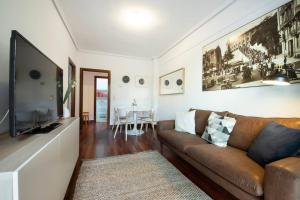a living room with a couch and a flat screen tv at Apartamento agradable con parking en Gros in Donostia-San Sebastián