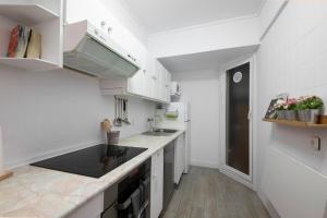 a kitchen with white cabinets and a black counter top at Apartamento agradable con parking en Gros in Donostia-San Sebastián
