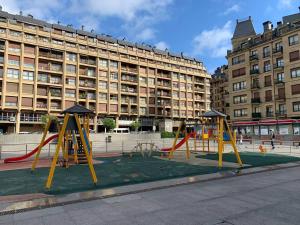 a playground in front of a large building at Apartamento agradable con parking en Gros in Donostia-San Sebastián