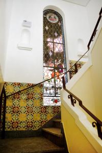 a stairway with a mosaic wall and a stained glass window at Pousada Lorde Inglês in Recife