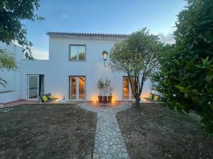 a white house with a tree in front of it at Casas dos Netos in Rio Maior