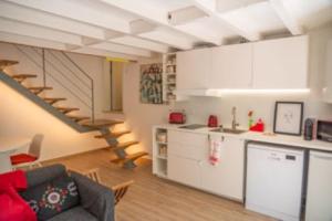a living room with a kitchen and a staircase at Casas dos Netos in Rio Maior