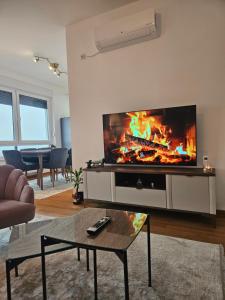 Una sala de estar con un televisor de pantalla plana grande en una pared. en Lux View apartment, en Banja Luka