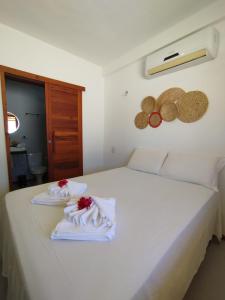 a white bed with two towels on top of it at Xalé da Xica in Amontada