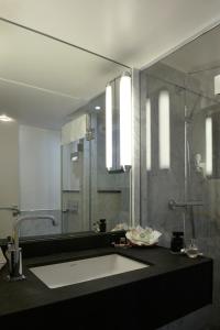 ein Bad mit einem Waschbecken und einer Dusche in der Unterkunft Folkestone Opéra in Paris
