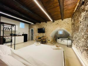a room with a white bed and a stone wall at Antrum Loft in Salerno