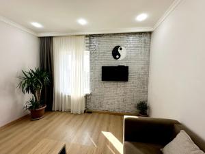 a living room with a couch and a brick wall at Good dayy in Yerevan