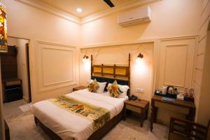 a bedroom with a bed and a desk with a phone at Captain Villa Heritage House in Varanasi